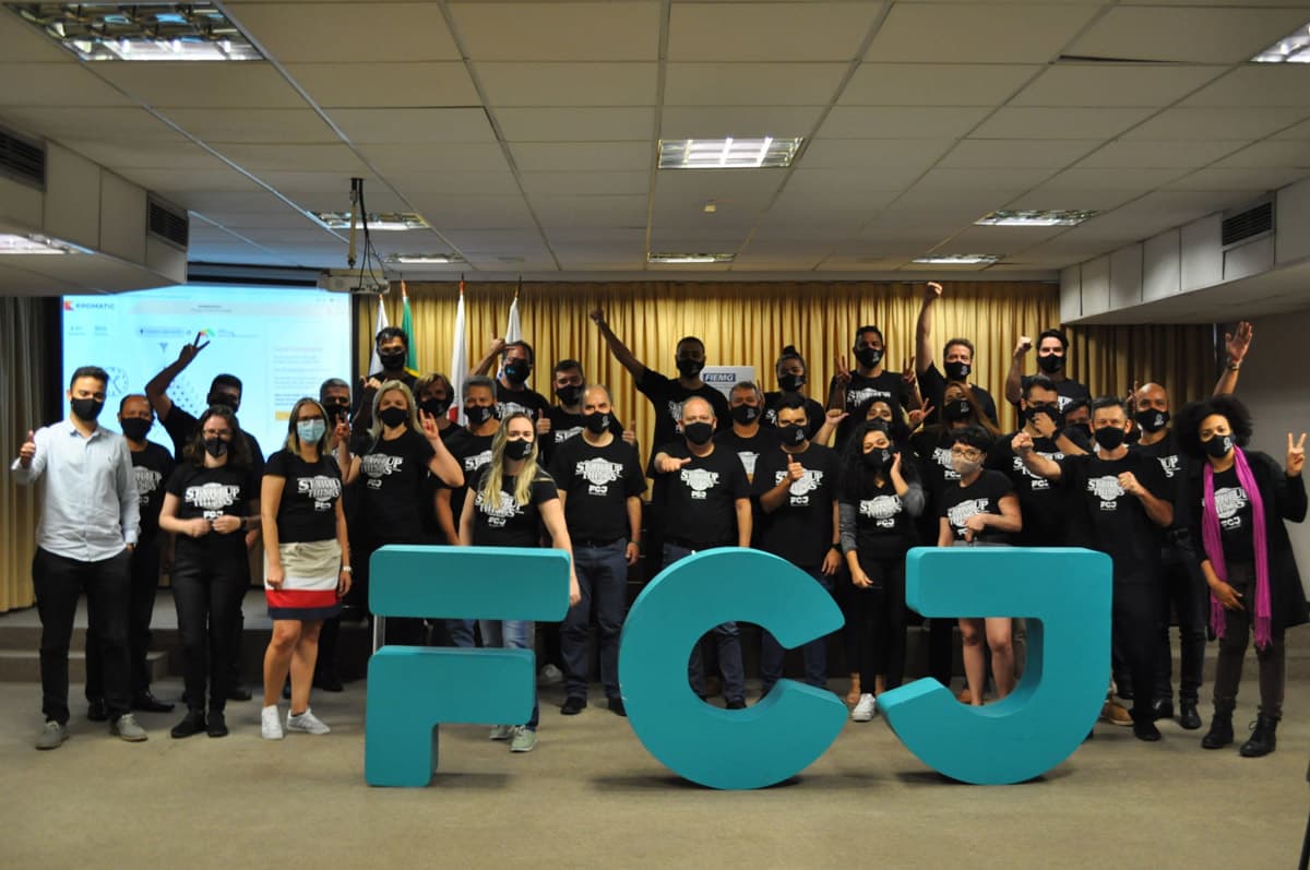 Time FCJ reunido em imersão com as letras FCJ em ciano